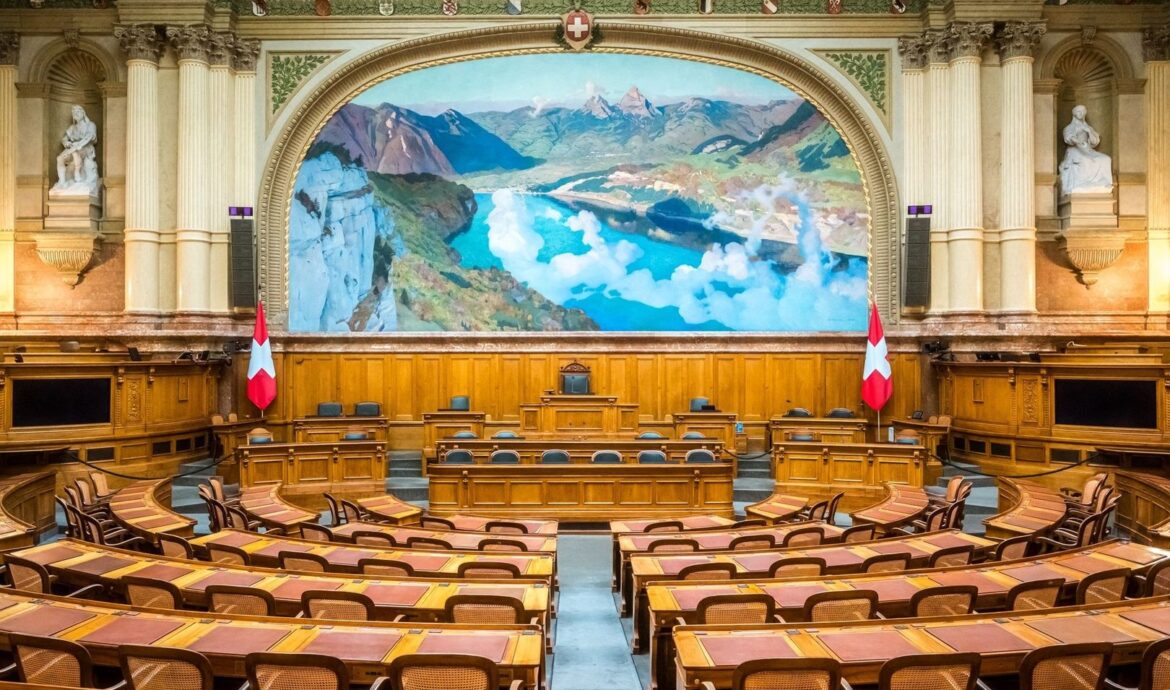 Empty Swiss parliamentary chamber with flags and Alpine mural
