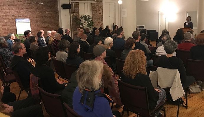Audience listening to a speaker at a community meeting